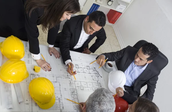 Architecten zitten aan tafel en kijken naar een project — Stockfoto