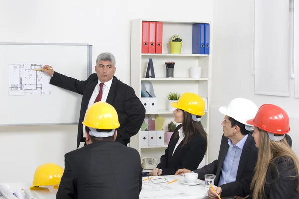 Arkitekt ger presentation till en liten företagskoncern. — Stockfoto