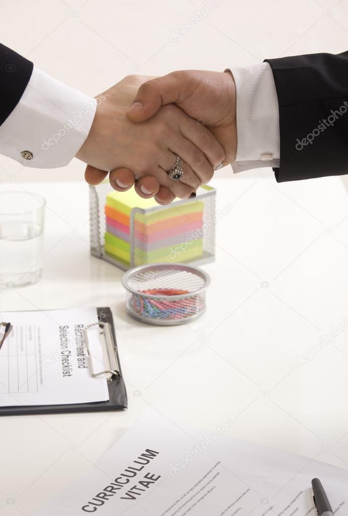 woman shaking hands with manager at job interview closeup