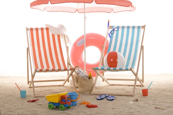 Пляжное кресло с красочными песчаными игрушками — стоковое фото