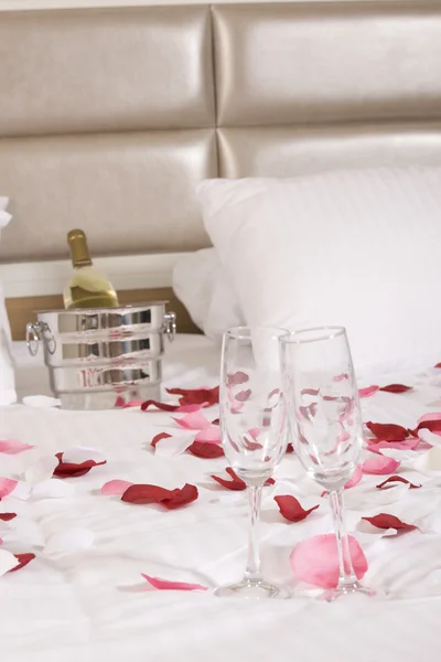 Hotelkamer met groot bed en rode bloemen — Stockfoto