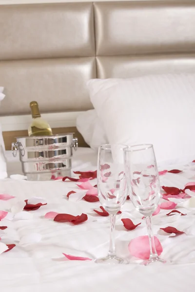Otel odasında büyük yatak ve kırmızı çiçekler Telifsiz Stok Fotoğraflar