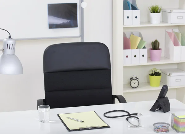 Mesa de escritório médico e cadeira preta com estetoscópio e w — Fotografia de Stock