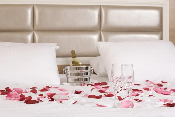 Kamar hotel dengan tempat tidur besar dan bunga merah — Stok Foto