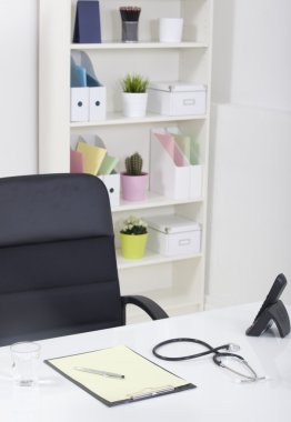Doktor ofis masa masa ve siyah sandalye stetoskop ve w