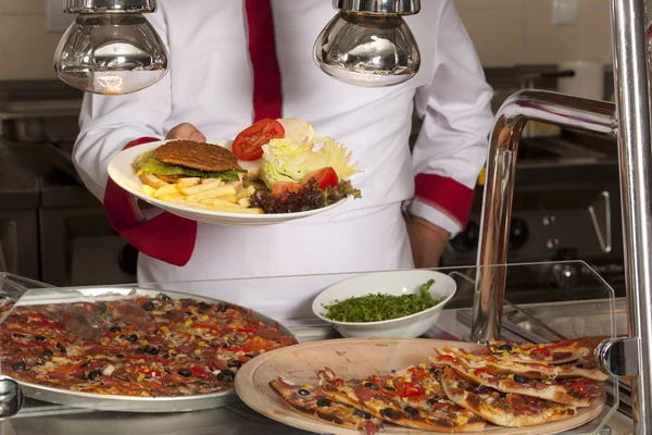 Шеф-повар, стоящий за бургером, спагетти и пиццерией — стоковое фото
