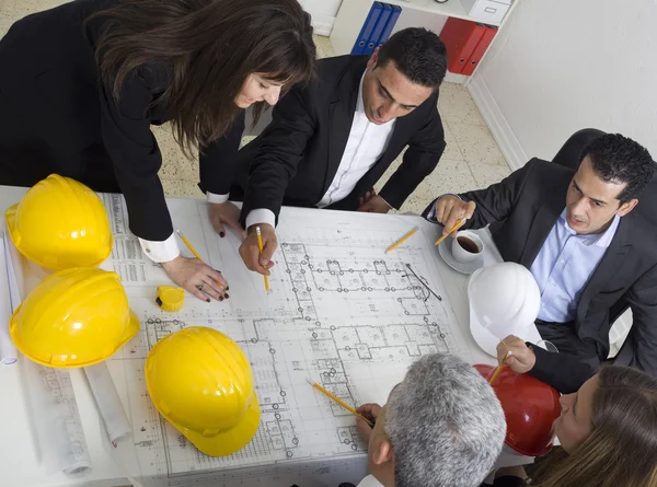 Architects sitting at table and looking at a project — Stock Photo, Image