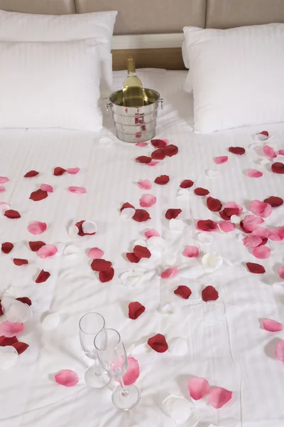 Hotel room with big bed and red flowers — Stock Photo, Image