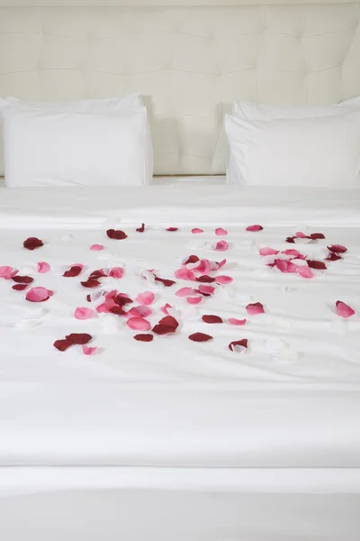 Hotelkamer met groot bed en rode bloemen — Stockfoto