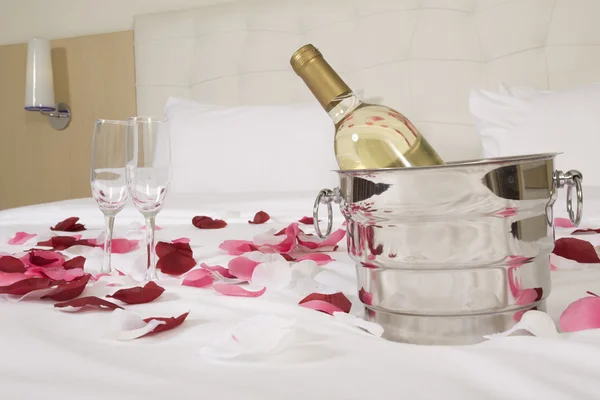 Hotelový pokoj s velkou postelí a červené květy — Stock fotografie