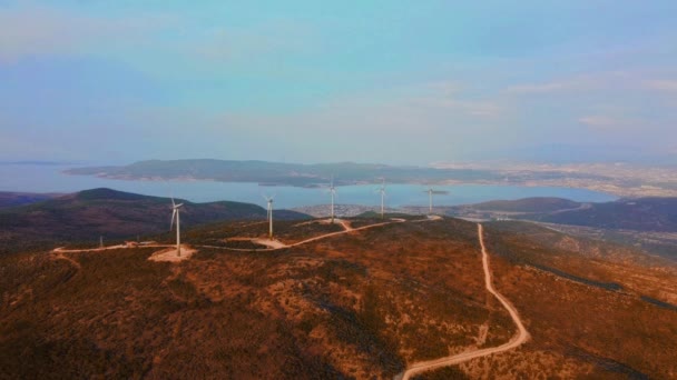 Muchy dronów nad parkiem wiatraków. Widok z powietrza na farmę z turbinami wiatrowymi. Turbiny wiatrowe generujące czystą energię odnawialną na rzecz zrównoważonego rozwoju. — Wideo stockowe