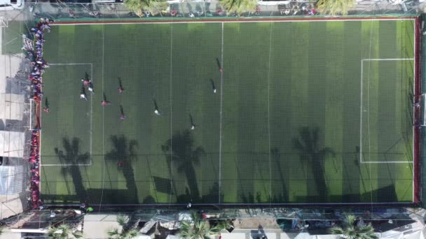 Vista dall'alto di un drone che scatta foto aeree di bambini che giocano a calcio su un campo da calcio — Video Stock
