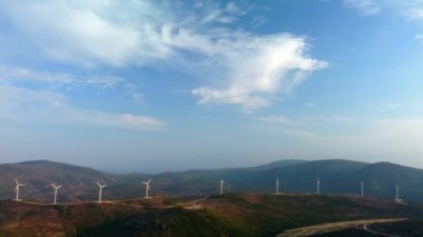 Drone bir yel değirmeni parkının üzerinde uçuyor. Rüzgar türbinli bir çiftliğin hava görüntüsü. Rüzgâr Güç Türbinleri Sürdürülebilir Gelişme İçin Temiz Yenilenebilir Enerji Üretiyor.