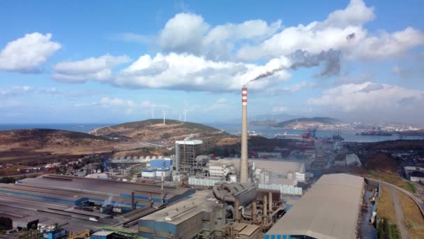 Vista aérea de la contaminación del medio ambiente: una tubería con humo y turbinas eólicas. Zona industrial con un gran humo blanco y rojo tubo grueso blanco se vierte de la tubería de fábrica. — Vídeos de Stock