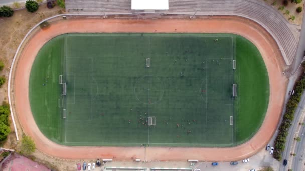 サッカー場でサッカーをしている子供たちの空中撮影ドローンのトップビュー — ストック動画