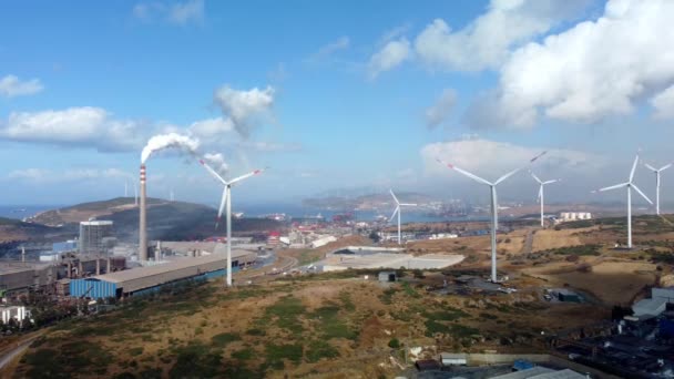 污染环境的空中景观：带有烟雾和风力涡轮机的管子。大红白相间的工业园区从工厂的管道中喷出浓浓的白烟. — 图库视频影像