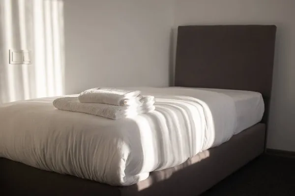 ホテルのベッドの上に積層された白いきれいなタオル — ストック写真
