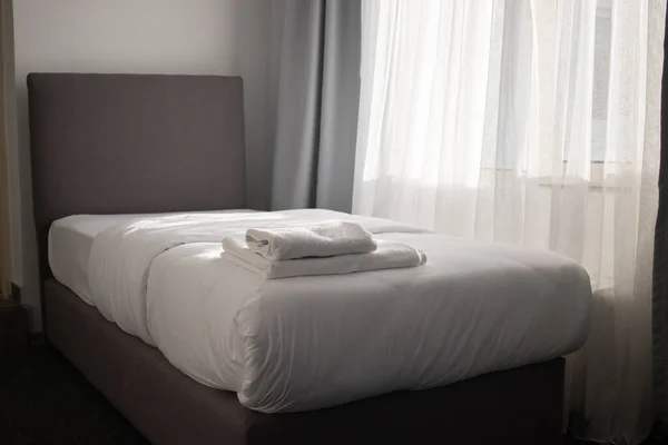 White clean towels stacked on the hotel bed — Stock Photo, Image