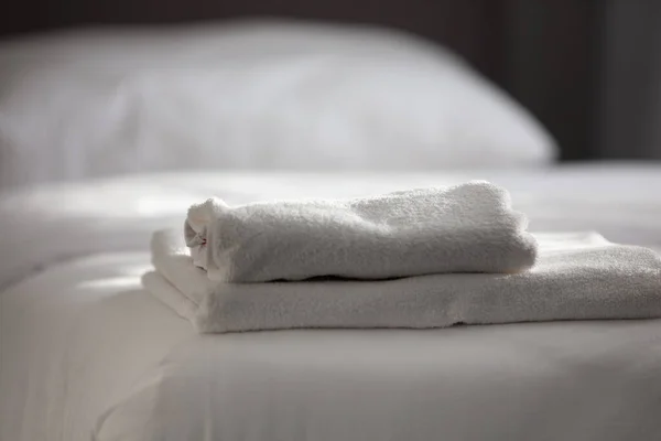 Witte schone handdoeken gestapeld op de hotelbed — Stockfoto