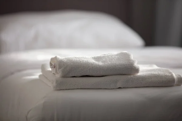 सफेद स्वच्छ तौलिए होटल बिस्तर पर ढेर — स्टॉक फ़ोटो, इमेज