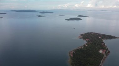 Denizde bir ada. Sakin mavi denizin ortasındaki yeşil tropikal adanın harika drone görüntüsü 