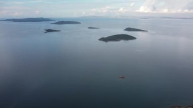 Denizde bir ada. Sakin mavi denizin ortasındaki yeşil tropikal adanın harika drone görüntüsü 