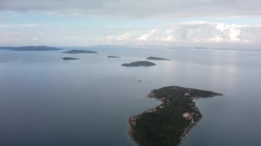 Denizde bir ada. Sakin mavi denizin ortasındaki yeşil tropikal adanın harika drone görüntüsü 