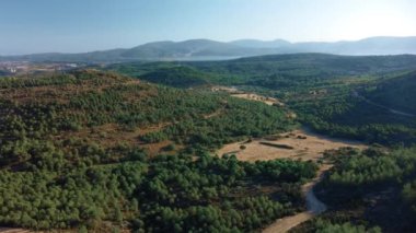 Birçok tarla, tarım arazisi, tarım arazisi, deniz ve dağ arka planında uçuyor. Yüksek kalite 4k görüntü