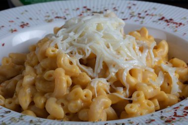 Mac and cheese, american style macaroni pasta with cheesy sauce on dark rustic table, top view. High quality photo