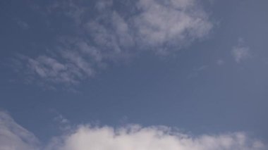 Zaman atlamalı bulutlar, yuvarlanan kabarık bulutlar hareket ediyor, beyaz ışık bulutları zaman atlaması yaşıyor. Mavi gökyüzü boyunca akan bulutlar, arka planda mavi gökyüzü olan beyaz bulutların zaman ayarlı mavi gökyüzü boyunca. Yüksek kalite 4k görüntü