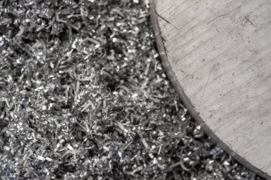 Gülen makinenin talaşı üzerinde büyük magnezyum çubuğu. Makro atış. Üst görünüm endüstriyel yakın çekim fotoğrafı. Girdap magnezyum talaşlarının üzerindeki metal çıkıntının fotoğrafı. Endüstriyel teknoloji atölyesi. Teknoloji konsepti geçmişi.