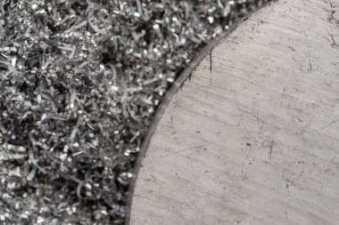 Gülen makinenin talaşı üzerinde büyük magnezyum çubuğu. Makro atış. Üst görünüm endüstriyel yakın çekim fotoğrafı. Girdap magnezyum talaşlarının üzerindeki metal çıkıntının fotoğrafı. Endüstriyel teknoloji atölyesi. Teknoloji konsepti geçmişi.