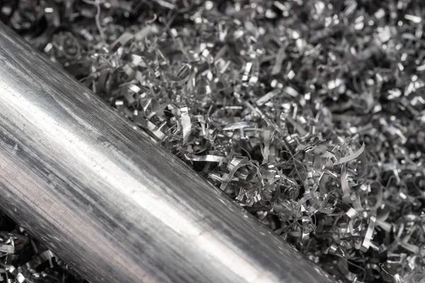 鉱業機械からの削り出しのアルミビレット 工業用クローズアップ写真 旋回アルミニウム削り出し上の2つの金属ロッドのサイドビュー写真 工業技術ワークショップ クローズアップビュー — ストック写真