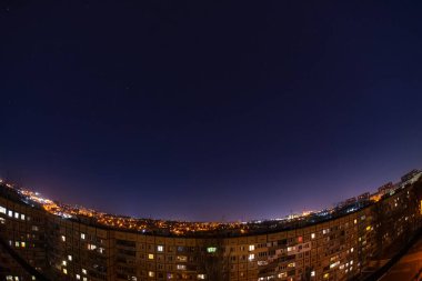 Night starry sky city view from roof high rise building fisheye. Night starry cityscape.