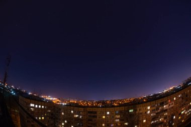 Night starry sky city view from roof high rise building fisheye. Night starry cityscape.