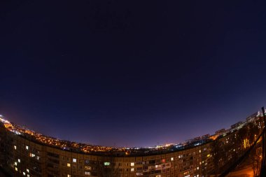 Night starry sky city view from roof high rise building fisheye. Night starry cityscape.