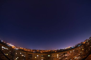 Night starry sky city view from roof high rise building fisheye. Night starry cityscape.