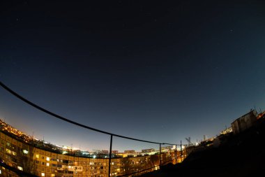 Night starry sky city view from roof high rise building fisheye