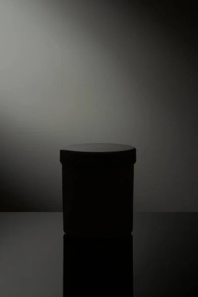 Low Light White Cosmetic Jar Reflection Gray Background Imágenes de stock libres de derechos