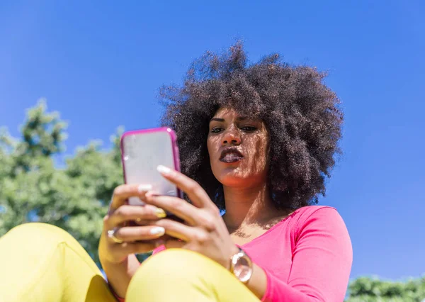 Красива Расова Жінка Афро Волоссям Дивиться Мобільний Телефон Відкритому Повітрі Ліцензійні Стокові Зображення