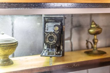 Çok eski ama bakımlı bir fotoğraf makinesi vitrininde sergileniyor.
