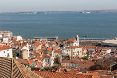 Arka planda deniz olan tipik Lizbon evlerinin çatılarının güzel manzarası.