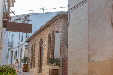 İspanya 'nın Alicante eyaletinde yer alan küçük bir belediye olan El Castell de Guadalest' in tipik bir caddesinde yürüyor.