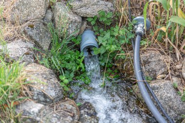 Tarım alanının sulanması için nehirden akan boru suyu.