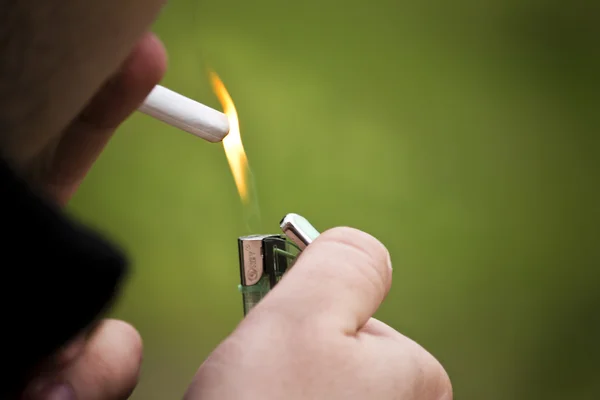 Fogo e cigarro segurando pelo homem — Fotografia de Stock