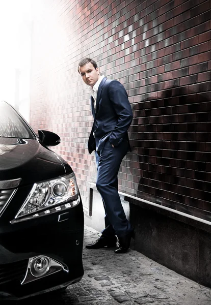 Homem de terno posando perto do carro — Fotografia de Stock