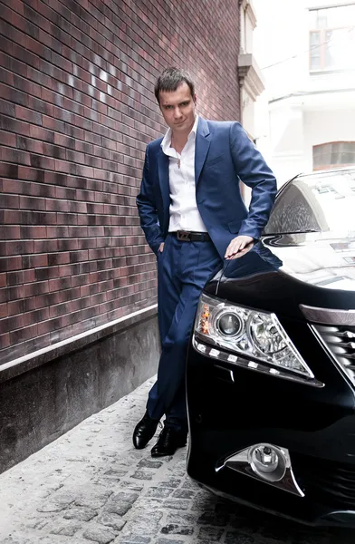 Man in suit posing near car — Stock Photo, Image