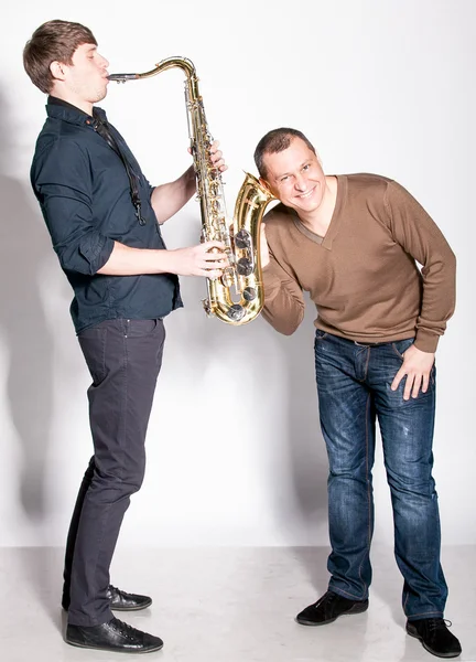 Man holding his ear close to saxophone — Stock Photo, Image