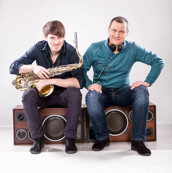 Saxophonist and dj sitting on loudspeaker — Stock Photo, Image