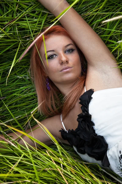 性感女孩躺在草丛中的肖像 — 图库照片
